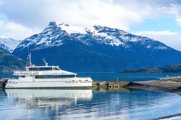 Pasajeros en la cubierta del catamarán frente a los glaciares del fiordo Última Esperanza